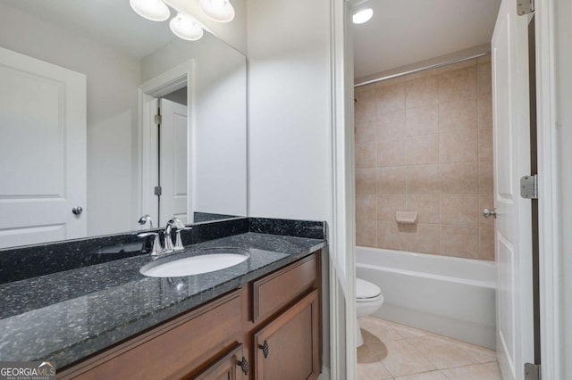 full bathroom with tile patterned floors, vanity, tiled shower / bath combo, and toilet