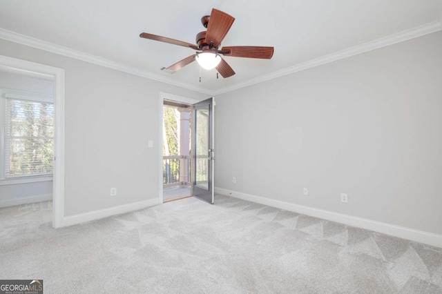 spare room featuring light colored carpet, a wealth of natural light, ornamental molding, and ceiling fan