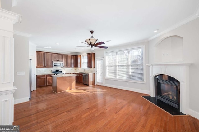 kitchen featuring backsplash, a center island, stainless steel appliances, and ornamental molding