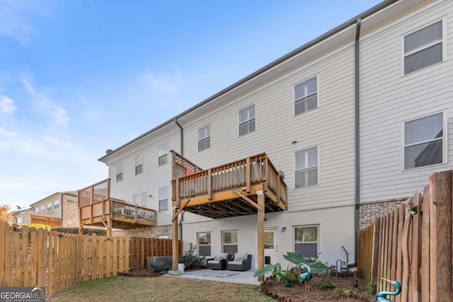 back of property with a yard, a patio area, and a wooden deck