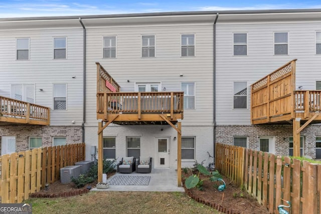 rear view of property with an outdoor living space and a patio area