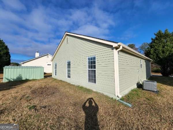 view of side of home with central AC unit