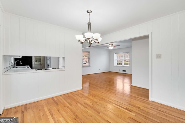 interior space featuring hardwood / wood-style flooring, ceiling fan with notable chandelier, and sink