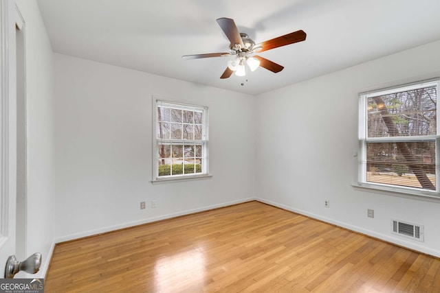 unfurnished room with ceiling fan, light wood-type flooring, and a wealth of natural light