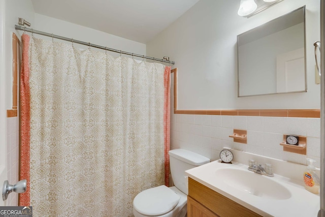 bathroom featuring vanity, toilet, and tile walls