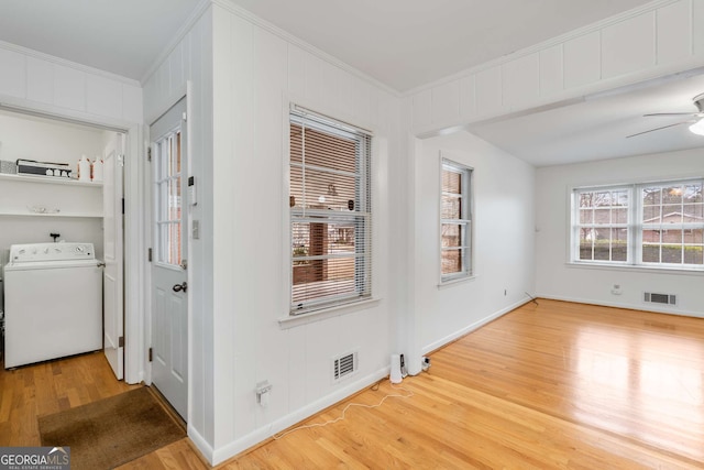 interior space with washer / clothes dryer, light hardwood / wood-style flooring, ceiling fan, and ornamental molding