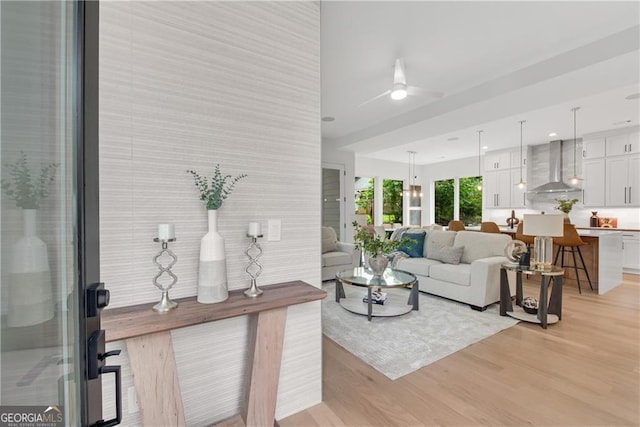 living room with light hardwood / wood-style flooring and ceiling fan