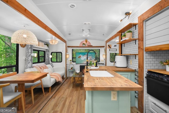 kitchen with pendant lighting, backsplash, wooden counters, green cabinets, and vaulted ceiling