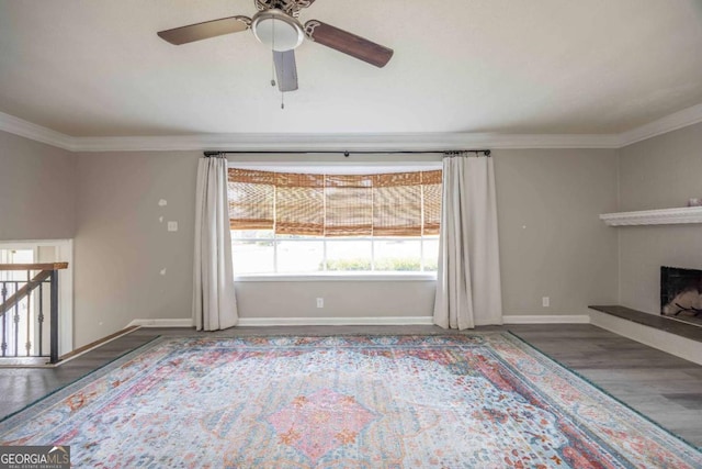 unfurnished living room featuring dark wood-type flooring, ceiling fan, and ornamental molding