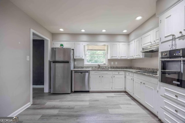 kitchen with light stone counters, sink, white cabinets, and appliances with stainless steel finishes