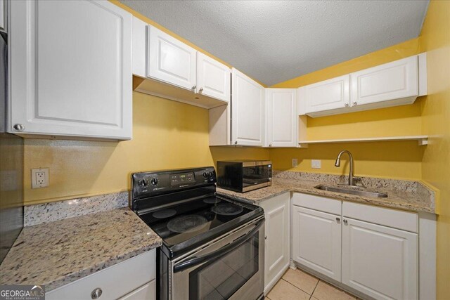 kitchen featuring white cabinets, sink, black electric range oven, and light tile patterned floors