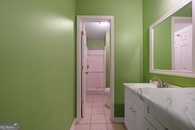 bathroom featuring vanity, a textured ceiling, a shower, tile patterned flooring, and toilet