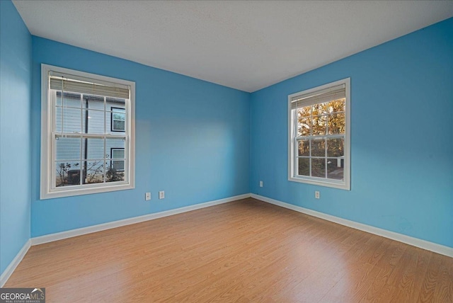 spare room featuring a textured ceiling and light hardwood / wood-style flooring