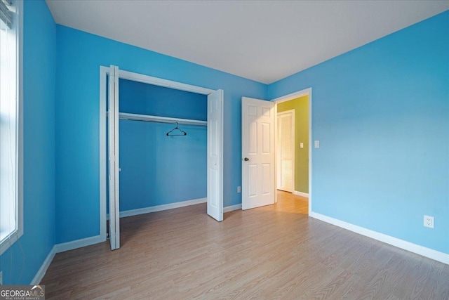 unfurnished bedroom featuring light hardwood / wood-style floors and a closet