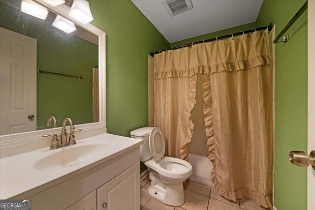 bathroom featuring tile patterned flooring, vanity, a shower with shower curtain, and toilet