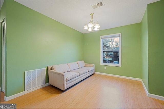 living area featuring hardwood / wood-style floors and an inviting chandelier