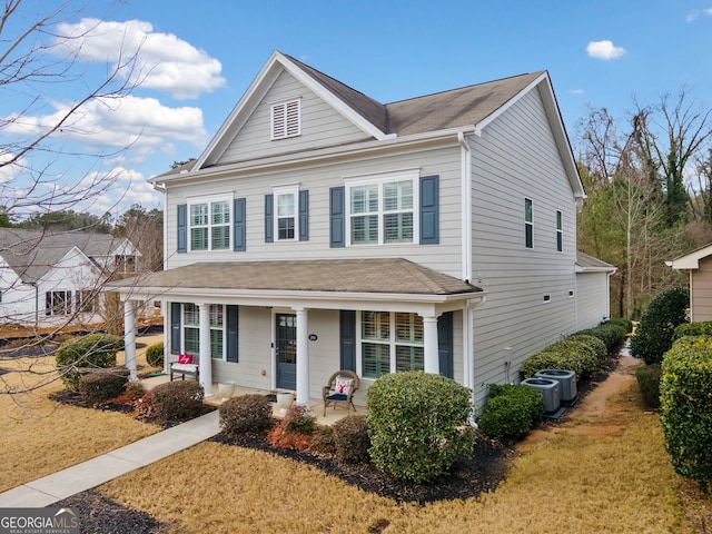 view of property featuring a front yard and central AC