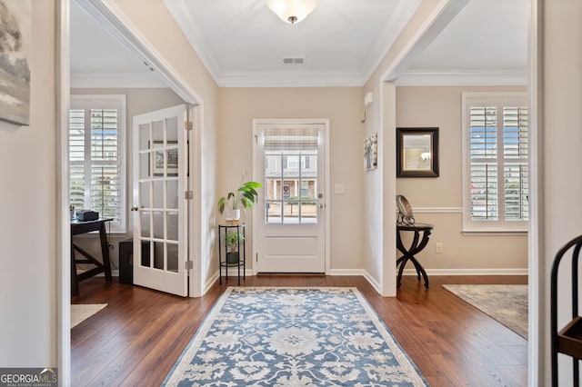 entrance foyer with dark hardwood / wood-style floors, ornamental molding, and a wealth of natural light