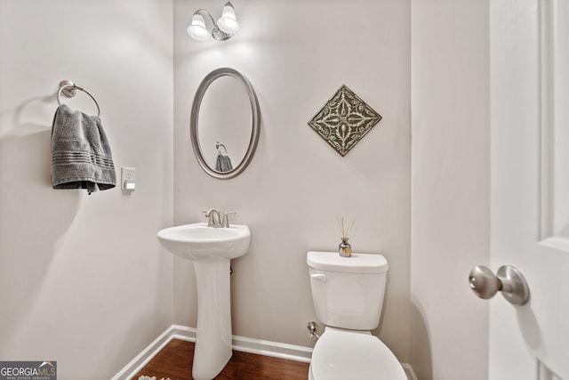 bathroom with toilet and wood-type flooring