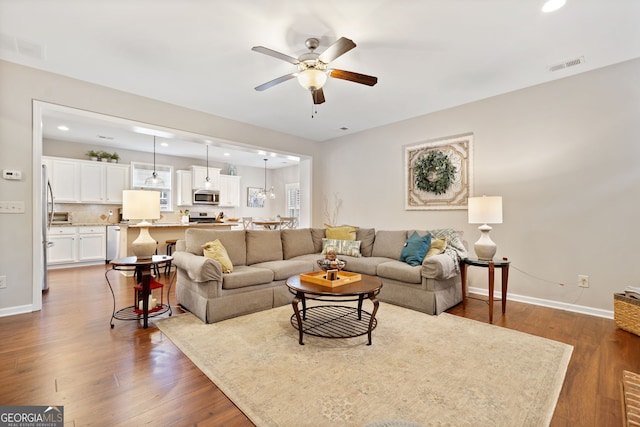 living room featuring dark hardwood / wood-style flooring and ceiling fan