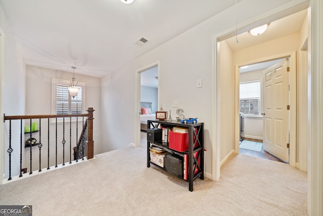 hallway featuring a healthy amount of sunlight and light carpet