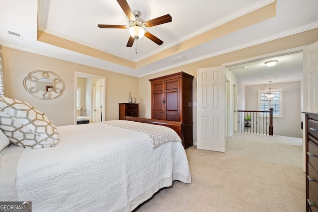 carpeted bedroom featuring a raised ceiling, ceiling fan, ensuite bathroom, and ornamental molding