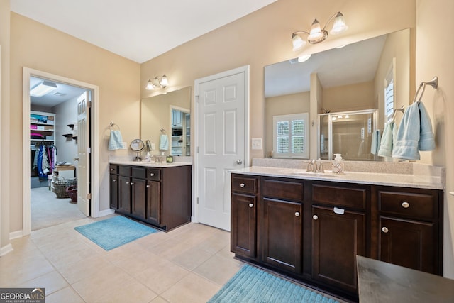 bathroom featuring tile patterned floors, vanity, and walk in shower