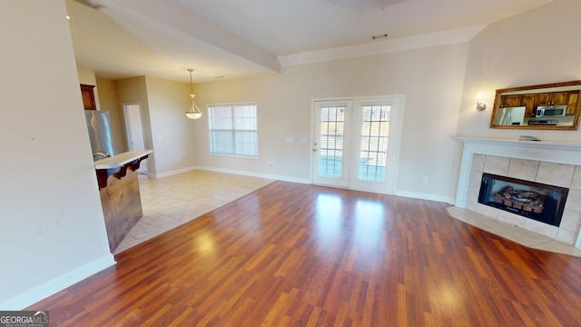 unfurnished living room featuring light hardwood / wood-style floors and a tile fireplace