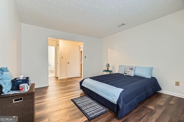 bedroom featuring dark hardwood / wood-style floors and a textured ceiling