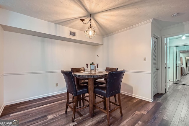 dining space featuring crown molding, dark hardwood / wood-style floors, and a textured ceiling