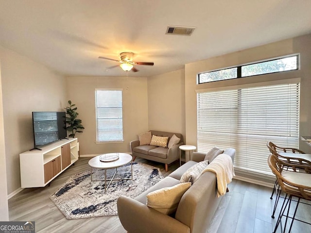 living room with a wealth of natural light, ceiling fan, and hardwood / wood-style floors