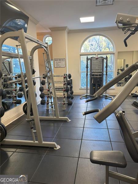 exercise room featuring crown molding