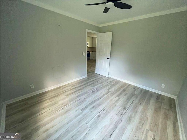 empty room featuring light hardwood / wood-style flooring, ceiling fan, and ornamental molding