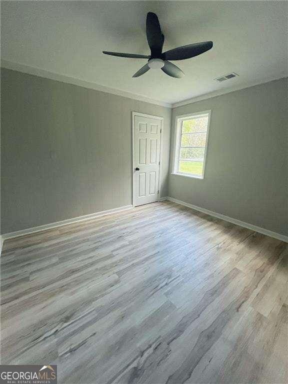 unfurnished bedroom featuring ceiling fan, light hardwood / wood-style floors, and crown molding