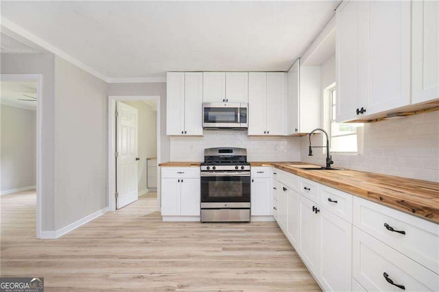 kitchen featuring wood counters, white cabinets, sink, light hardwood / wood-style flooring, and stainless steel appliances