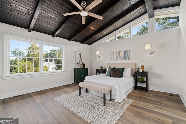 bedroom featuring hardwood / wood-style floors, ceiling fan, and beam ceiling