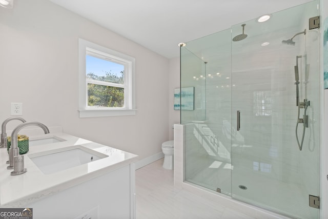 bathroom featuring vanity, toilet, and a shower with shower door