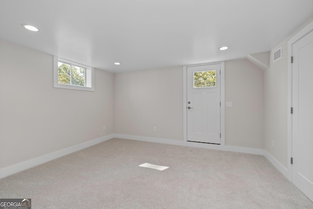 basement featuring light carpet