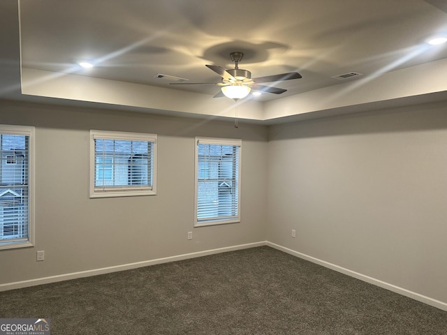 carpeted empty room featuring a tray ceiling and ceiling fan