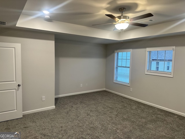 basement with ceiling fan and dark carpet