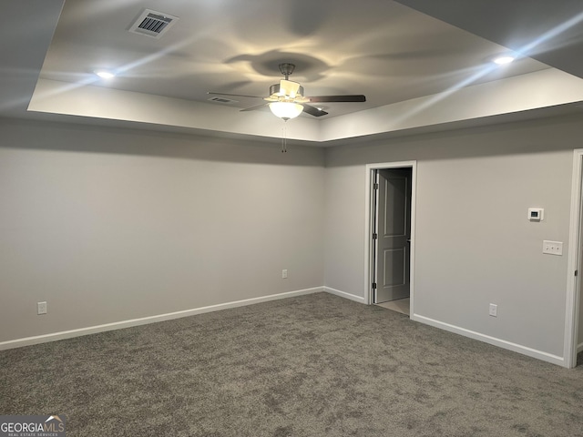 interior space with ceiling fan and a tray ceiling