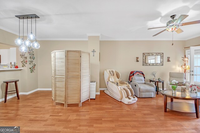 living room featuring crown molding, ceiling fan, and light wood-type flooring