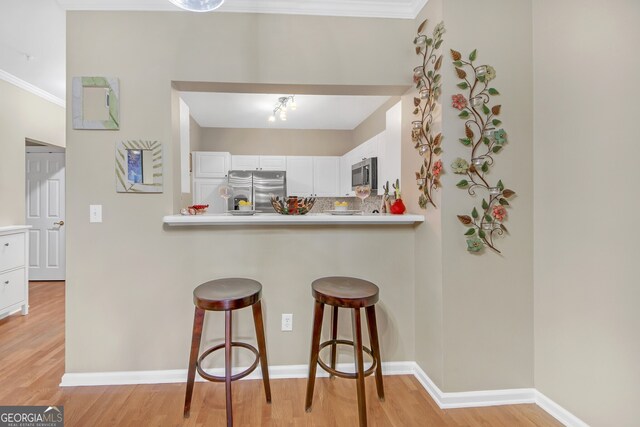 kitchen featuring white cabinets, stainless steel appliances, light hardwood / wood-style floors, and sink