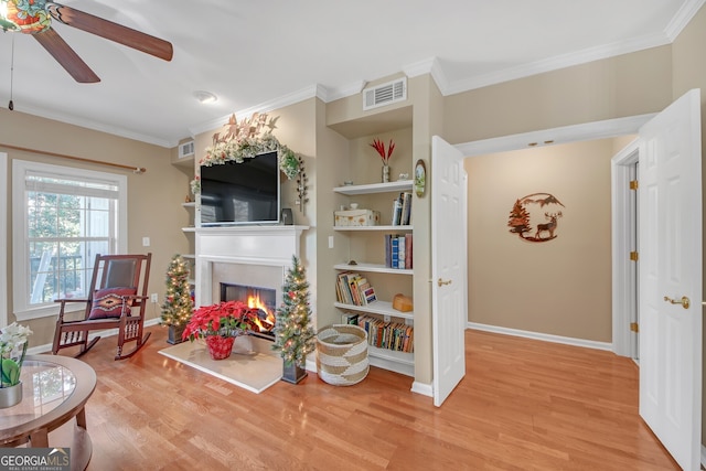 interior space featuring ceiling fan, wood-type flooring, and ornamental molding