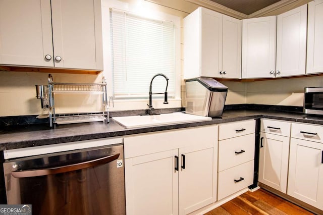 kitchen with crown molding, sink, appliances with stainless steel finishes, white cabinetry, and wood-type flooring