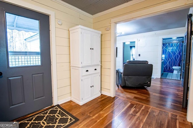 entrance foyer featuring dark hardwood / wood-style floors and wooden walls