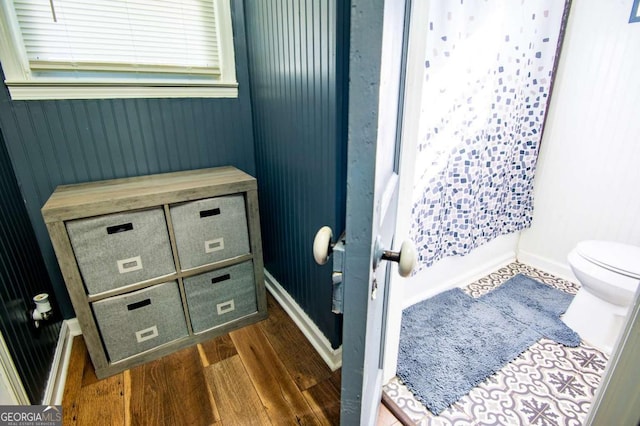 bathroom with toilet, wood-type flooring, and walk in shower