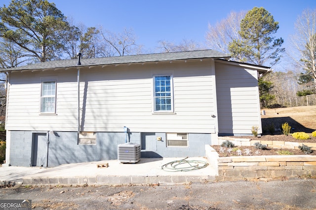 back of property with central AC and a patio