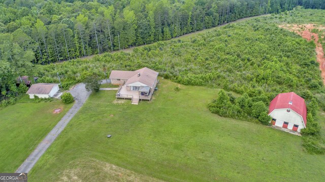 rear view of property featuring a wooden deck and a lawn