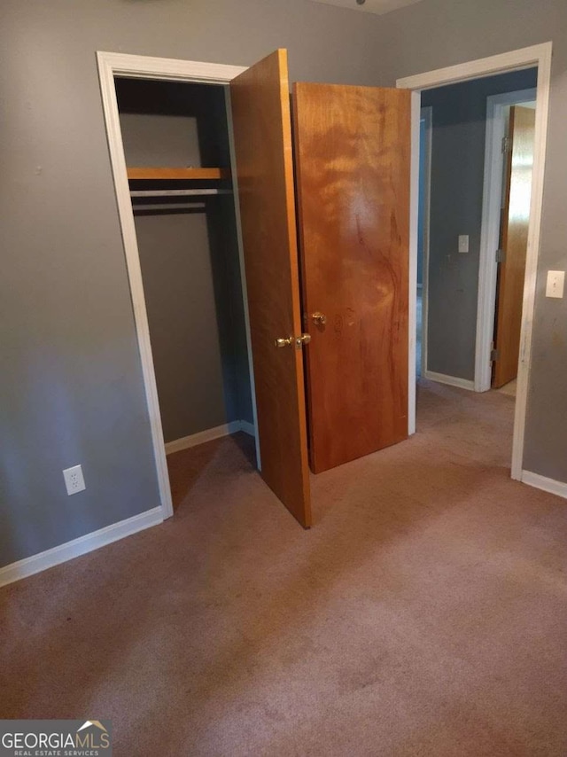 unfurnished bedroom with carpet flooring and a closet